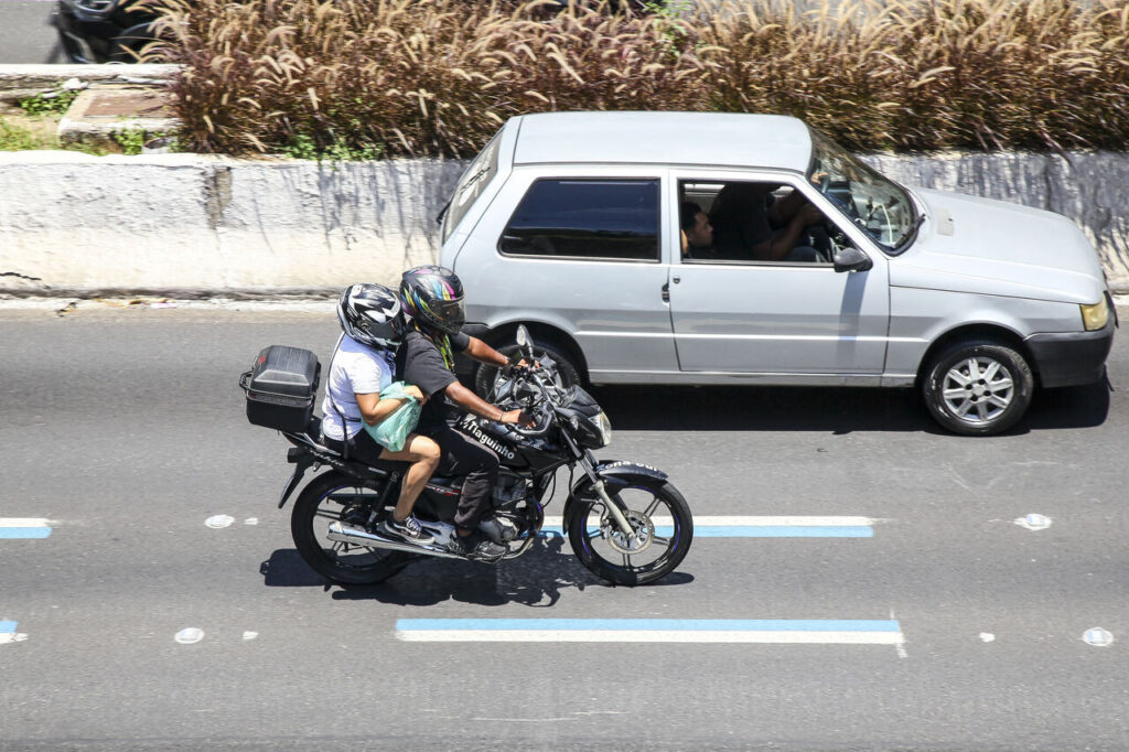 visão de duas pessoas em uma moto na rodovia