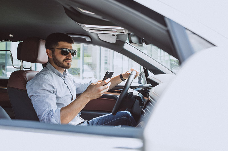 homem-de-negocios-bonito-usando-telefone-no-carro