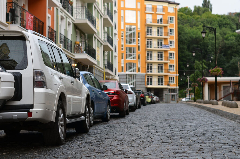 Longa fila de carros estacionados ao lado de prédios em SP