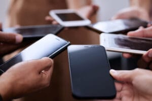 People, hands and smartphones together in circle for contact, connection and communication. Social media, team and group of mobile in closeup for networking, collaboration and employee synergy