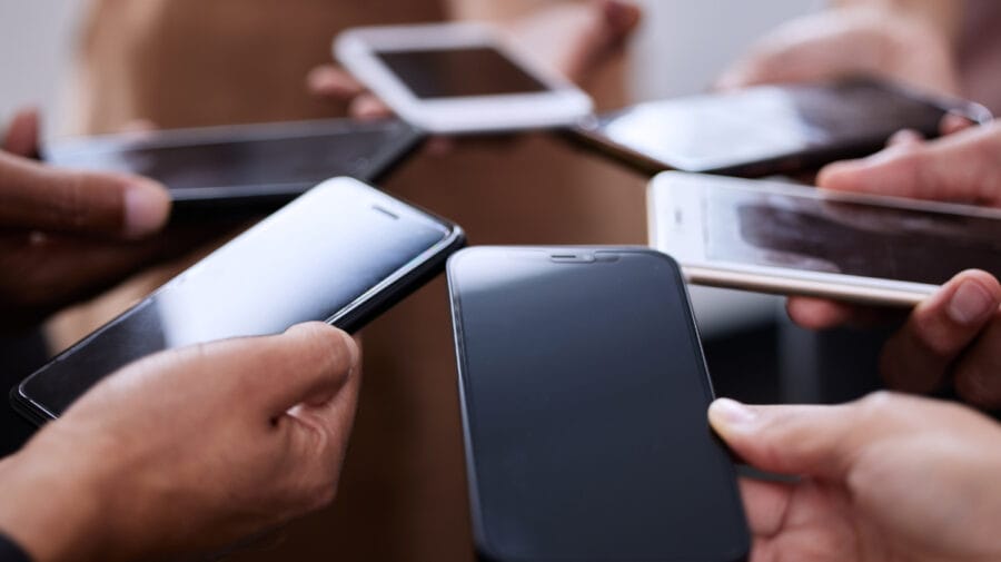 People, hands and smartphones together in circle for contact, connection and communication. Social media, team and group of mobile in closeup for networking, collaboration and employee synergy