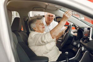 Casal idoso verifica espelhos e condições internas de um carro